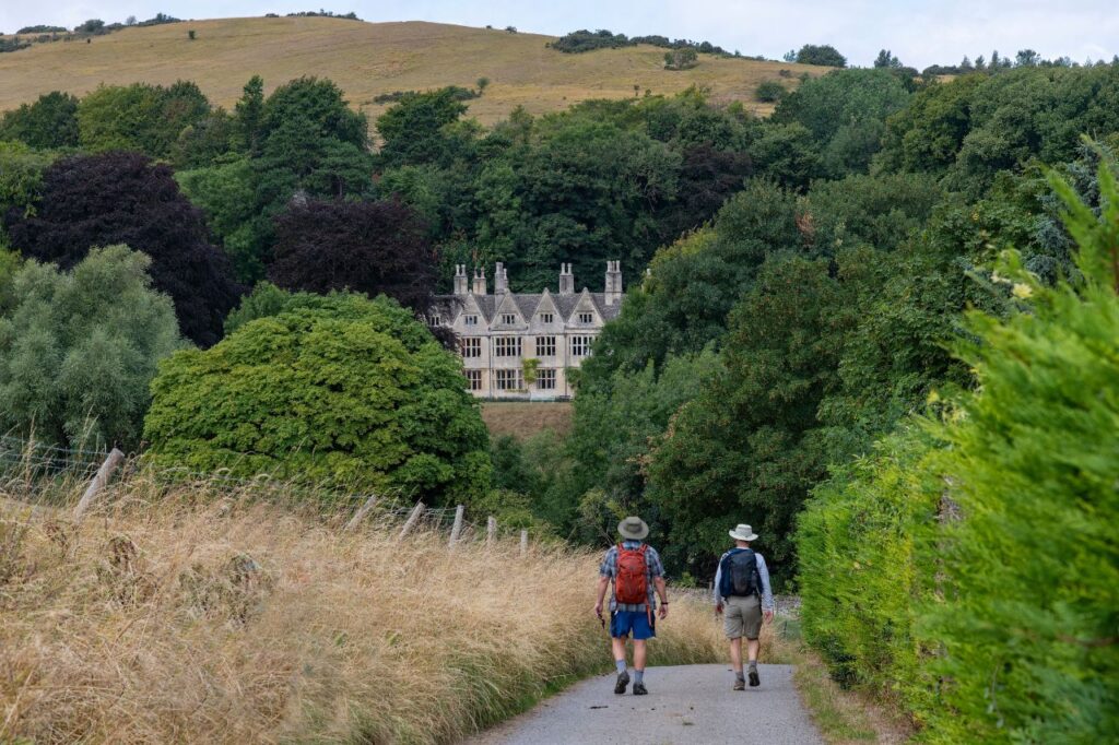 Walkers approaching Postlip Hall near Winchcombe, Cotswolds