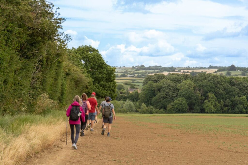 Walkers on the edge of a Cotswold field